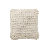 Coussin J-Line tricoté blanc posé sur un lit contemporain