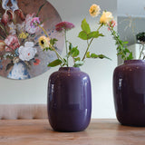 Vase Artic Purple sur une table en bois, décoré avec des fleurs