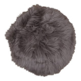 Coussin rond en peau d'agneau sur un tabouret scandinave
