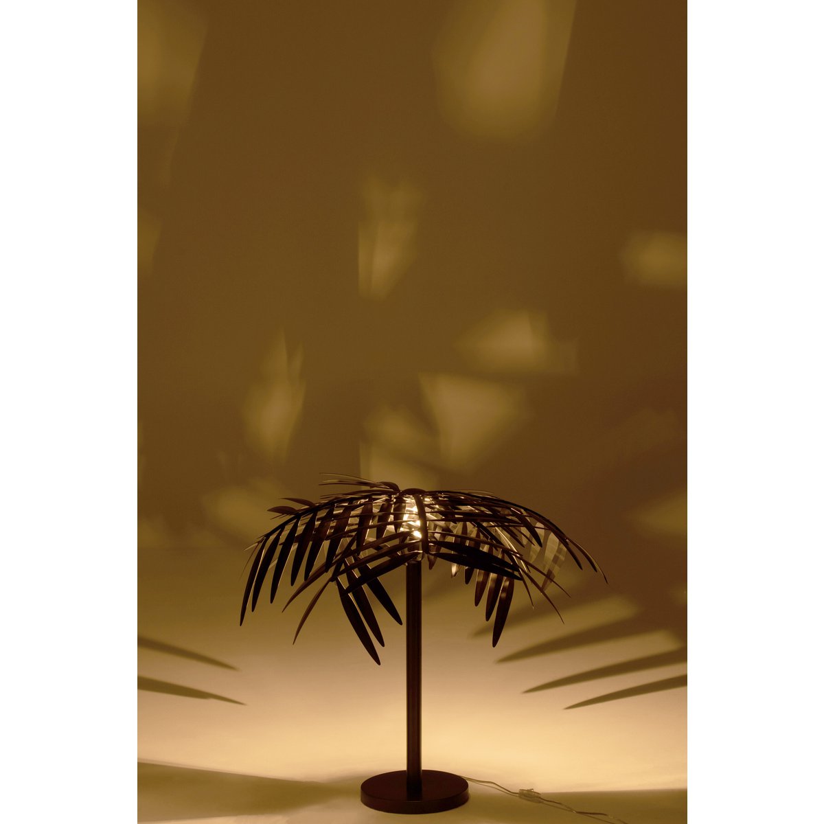 Lampe J-Line Leaf allumée dans un salon élégant.