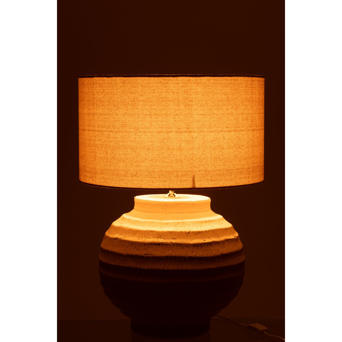 Lampe J-Line en terre cuite beige, placée sur une table moderne.