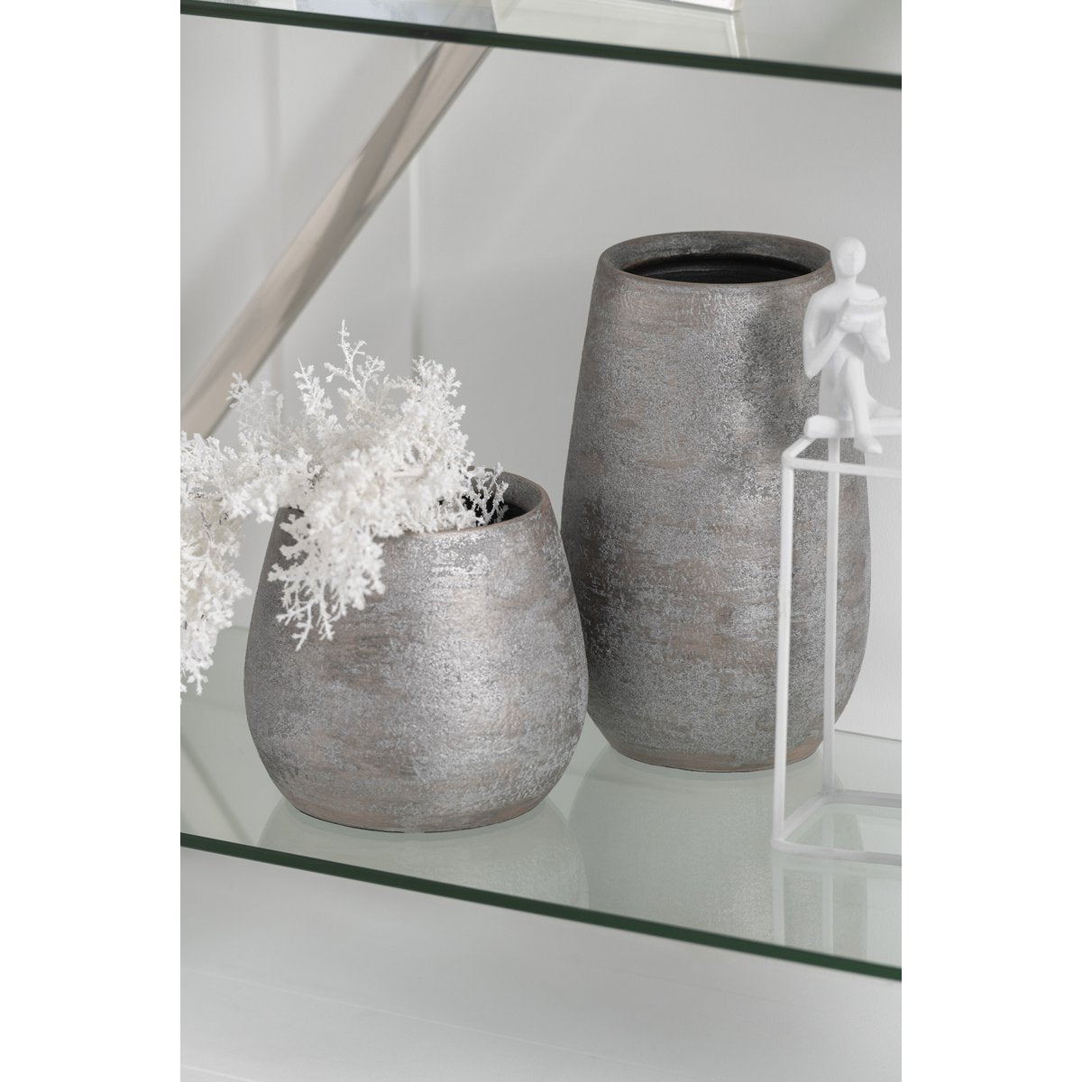 Vase en céramique brute argentée sur une table décorative