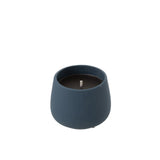 Bougie Cyra en ciment bleu sur un fond naturel