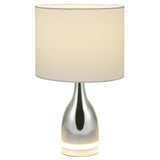 Lampe Cosima allumée sur une table moderne