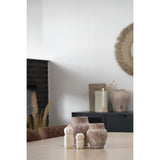Objet déco en ciment beige, placé sur une étagère minimaliste