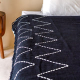Ambiance cosy avec le plaid Linggah sur un fauteuil