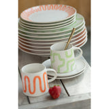 Mug J-Line Curve en porcelaine orange sur une table élégante