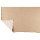 Plaid Teddy Rayures Beige drapé sur un canapé scandinave