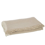 Plaid J-Line beige foncé sur un lit, ambiance cosy