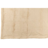 Couverture J-Line beige drapée sur un canapé moderne.