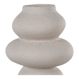 Vase sculptural beige en grès sur une table en bois