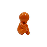 Statue Amigo Assis en résine orange, vue de profil