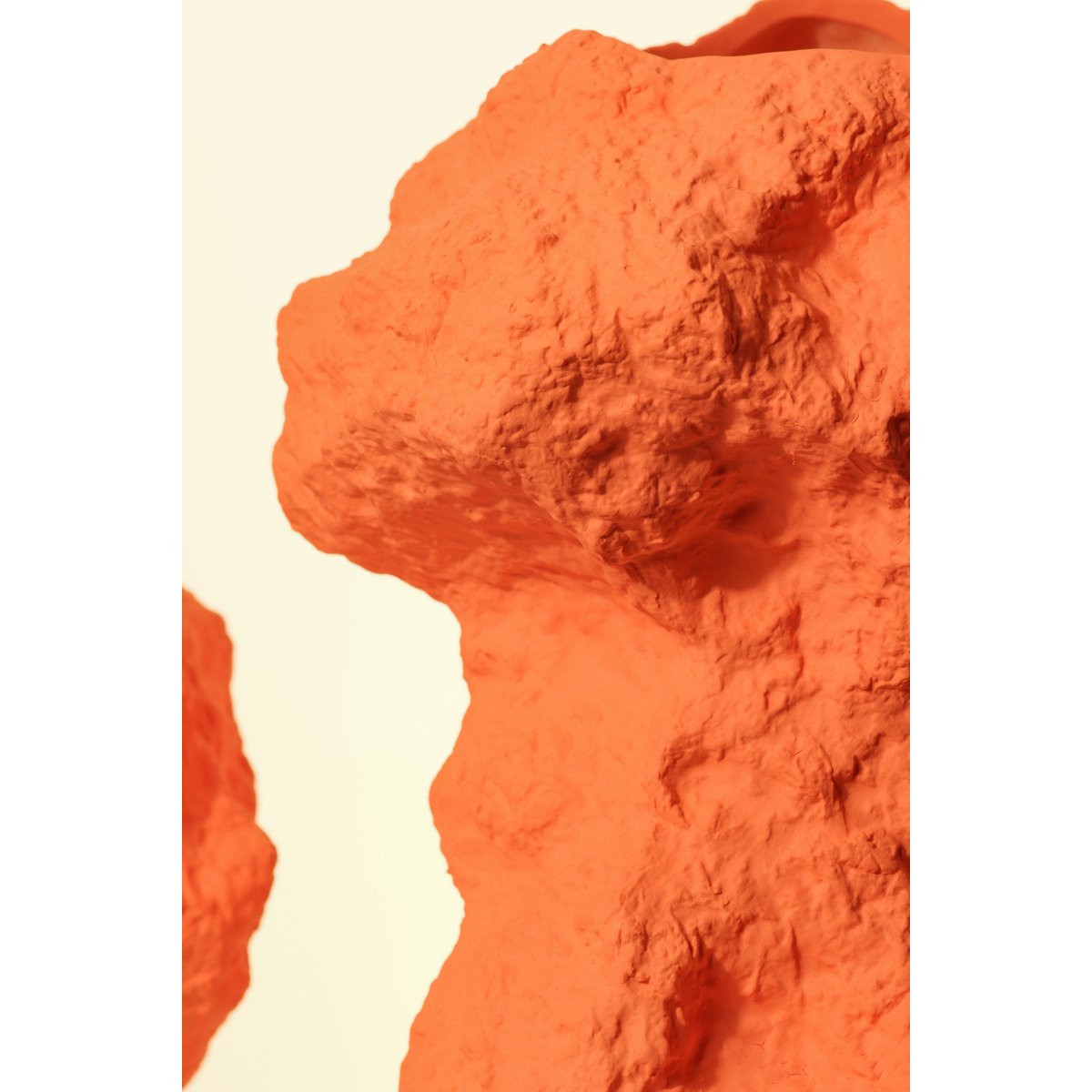 Vase en céramique orange avec des fleurs, ambiance chaleureuse