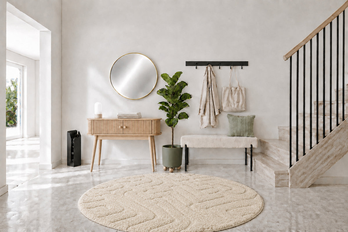 L'entrée de la rentrée : console en pin clair, banc bouclé écru, miroir rond doré et coussin vert sauge