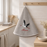 Essuie-mains rond brodé Cigogne envol Gris diamétre 60 cm en situation