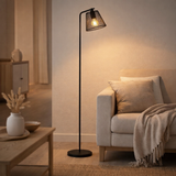 Lampe debout Korie, lampadaire en noir en noir, avec une prise E27, 140 cm de haut, pour le salon et le bureau. en situation