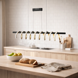 Le pendentif LED Belleza, le pendentif en métal moderne et le plastique noir, l'or et le blanc, avec des LED fermement construites, 100 cm de long. L'éclairage idéal pour le salon, la salle à manger ou la cuisine. en situation