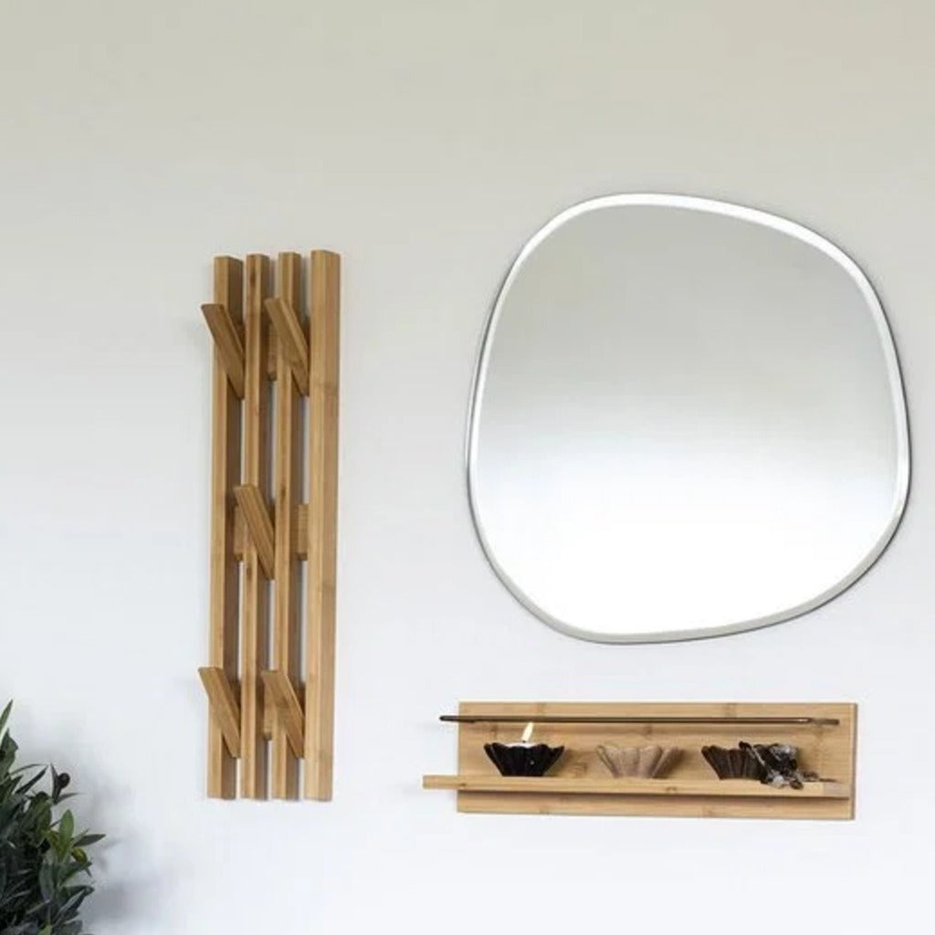 Porte-manteau mural en bambou fixé à plat contre le mur d'une entrée, à côté d'un miroir et d'une étagère